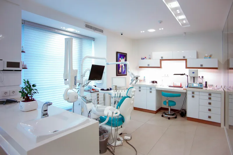 Diş kliniğinde hastasını muayene eden diş hekimi