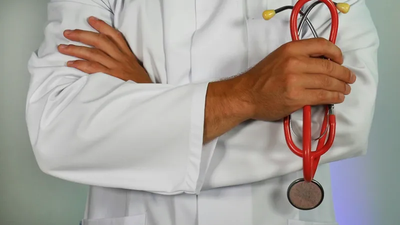 Muayenehanesinde hastasını değerlendiren doktor